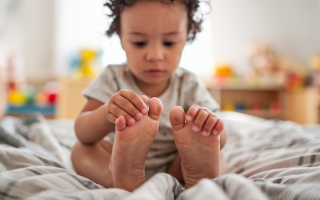 enfant-assis-lit-visage-concentre