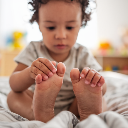 enfant-assis-lit-visage-concentre