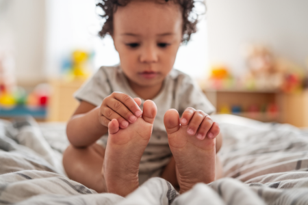 enfant-assis-lit-visage-concentre