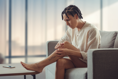 individu-canape-jambe-telephone-salon